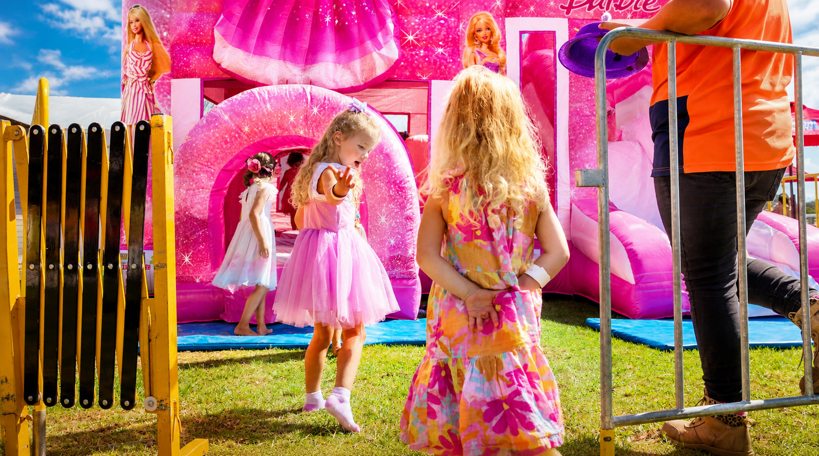 Kids playing at a pink Barbie themed bouncy castle
