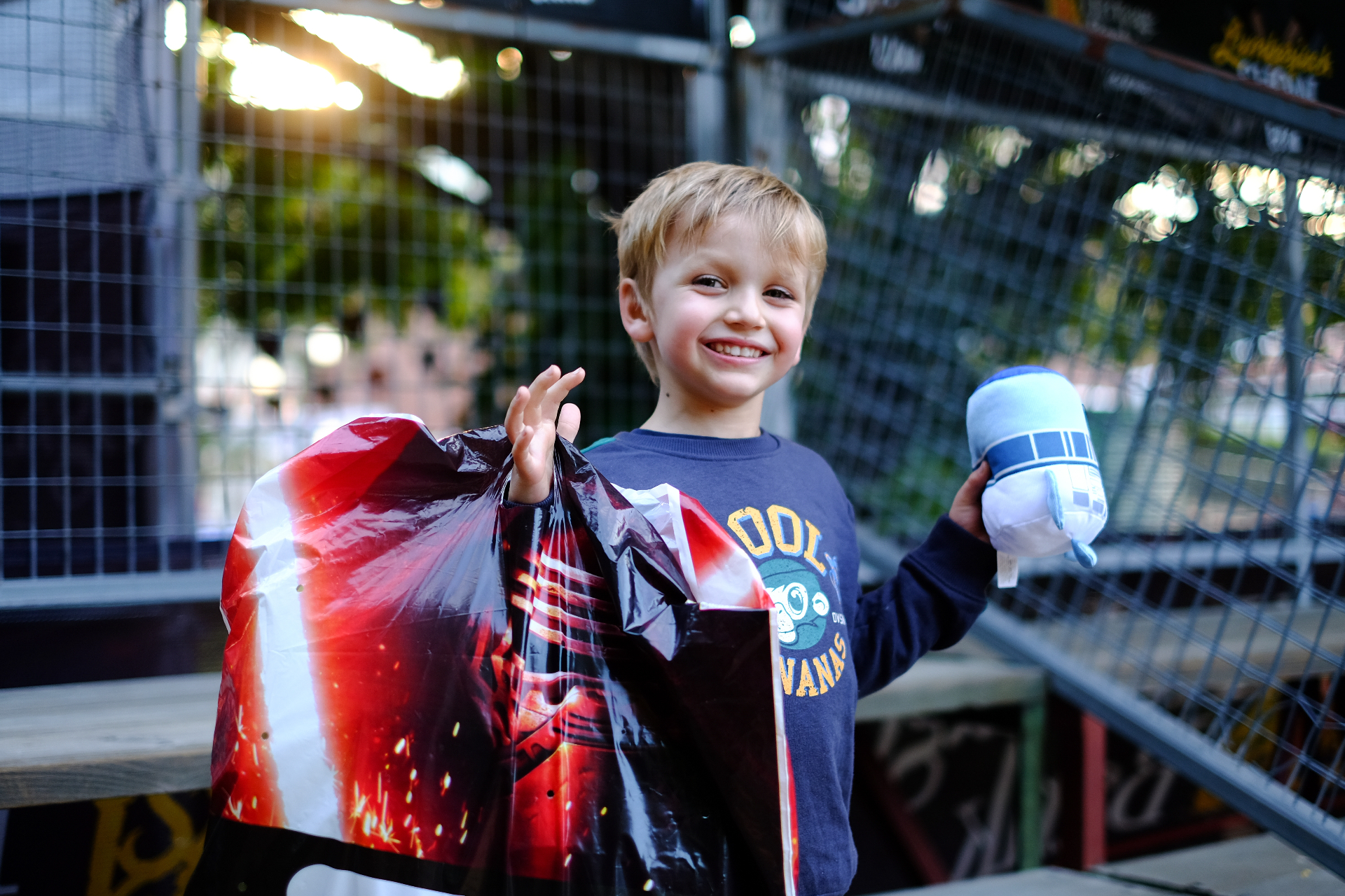Happy child holding a showbag and a plush toy at the fair